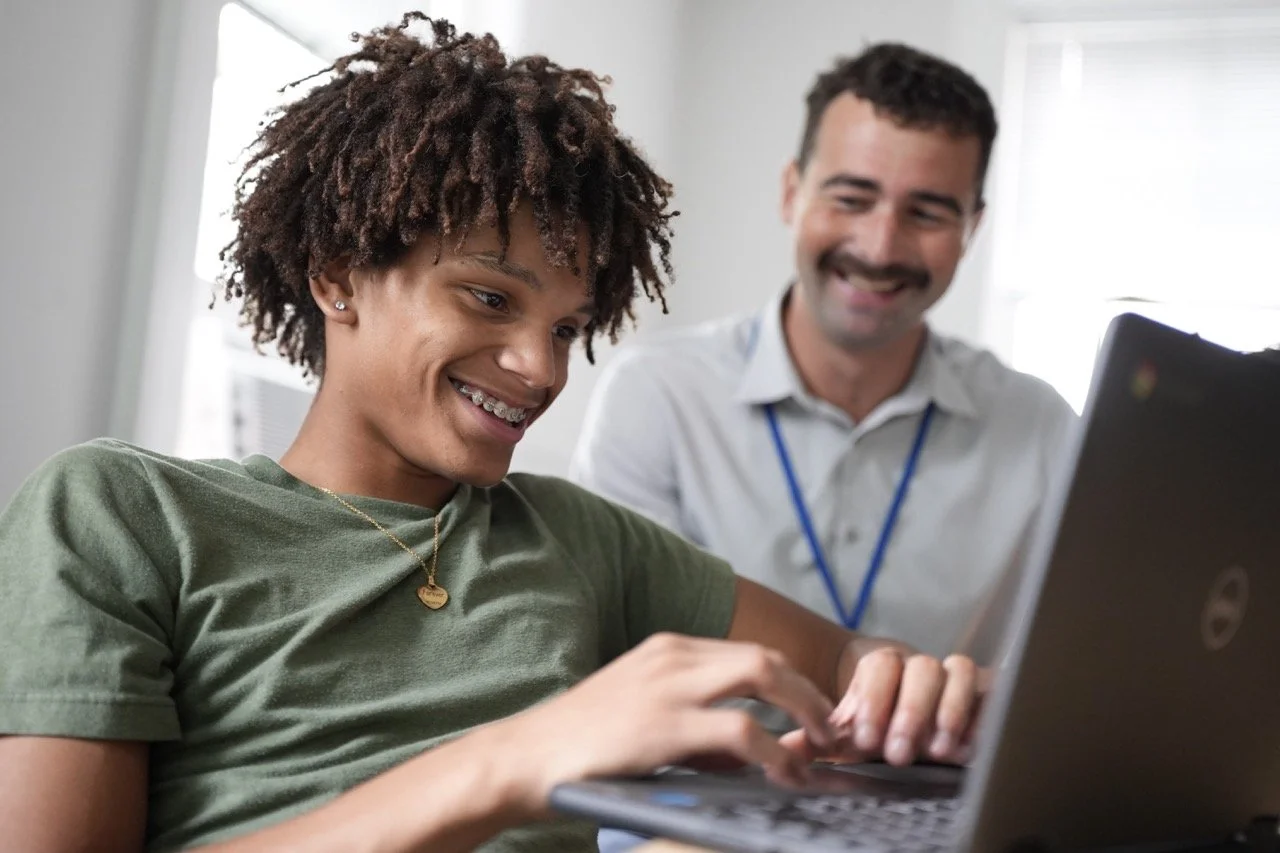 student and teacher with laptop